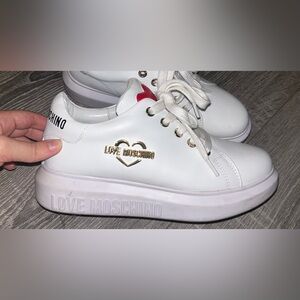 White leather platform sneakers with a gold heart logo. Lace-up closure. Size 8